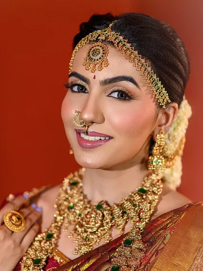 A joyful and radiant bridal portrait. The model's smile, combined with the warm, festive lighting, perfectly captures the spirit of a celebration like Diwali.