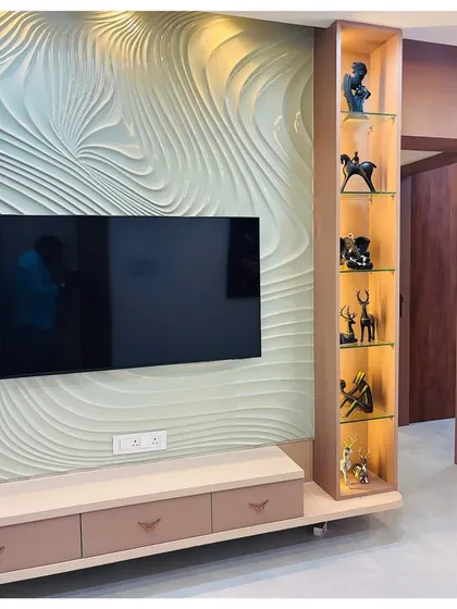 A close-up of the 3D textured TV wall, showing the intricate wave-like pattern and the soft, diffused light it creates. The floating console and display cabinet complete this artistic installation.