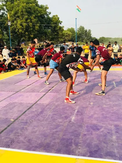 A raider from our academy attempts a kick touch during a competitive match on a purple mat, showcasing the athletic ability we nurture.