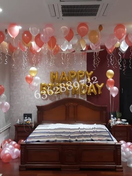Surprise your loved one with a decorated room. For this birthday, we filled the ceiling with dozens of helium balloons in shades of pink, red, and gold, creating an instant party atmosphere right in the bedroom.