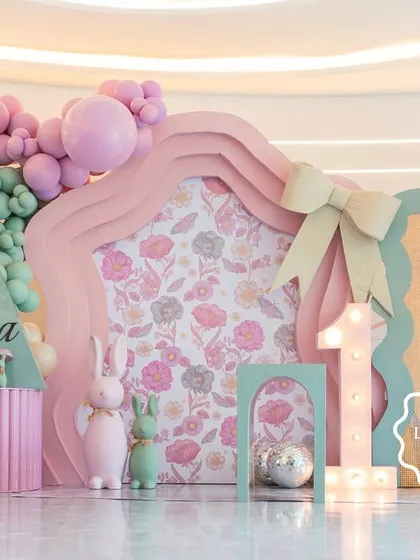 Welcome to "Aahana's Onderland," a whimsical first birthday party where every detail was crafted to inspire wonder. This custom-fabricated backdrop, with its soft pastel balloons and floral-print panels, set the stage for a magical celebration.