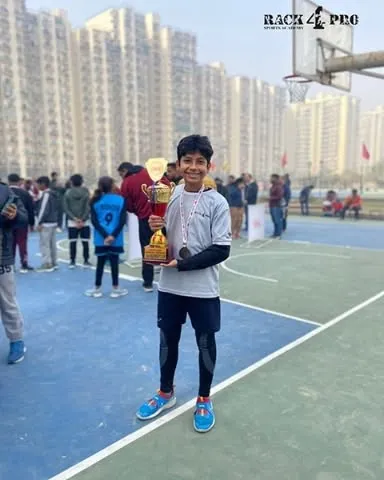 Seeing the pride on a player's face after a tournament win is what motivates us. This young champion from our academy is holding his trophy after a stellar performance in the winter league.