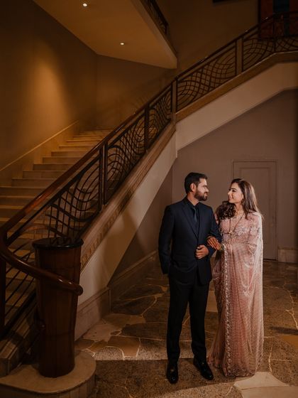 A full-length portrait of the couple on a grand staircase, creating a sense of timeless elegance and sophistication.