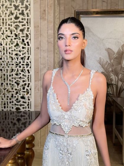 A sleek and sophisticated ponytail for a high-definition cocktail look. This style is clean, sharp, and modern, perfectly complementing the model's glamorous gown and diamond jewelry.