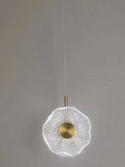 A delicate, flower-shaped pendant light with a brass center. This piece is ideal for adding a soft, feminine touch to a bedroom or reading corner.