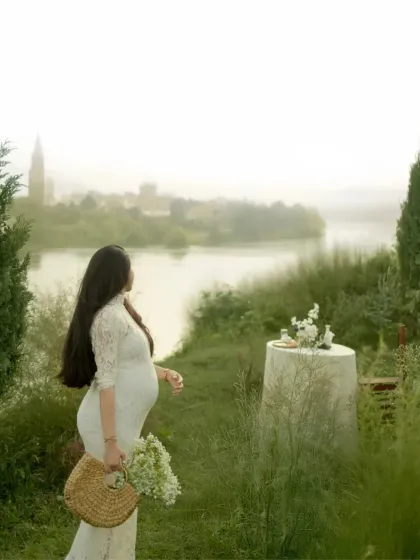 A moment of quiet contemplation by the water. The mother-to-be looks out at a serene, misty landscape, creating a poetic and beautiful portrait of anticipation.