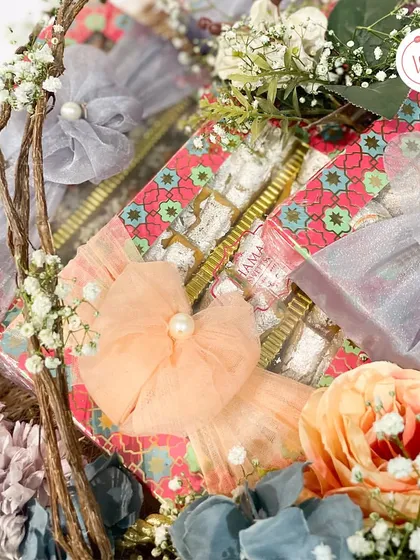 A detail shot of the mithai boxes, showing the delicate pearl and floral ribbon work.
