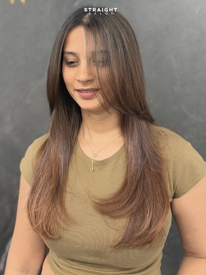 A sleek, face-framing layered cut finished with a smooth caramel blend. This look is the epitome of simple elegance.