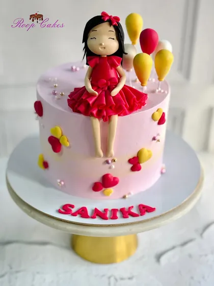 Sweet as sugar, cute as can be. This cake features a lovely doll in a red dress, surrounded by balloons and hearts.