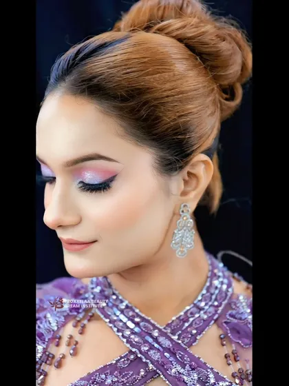 Party-ready and glowing all night long. This look features a beautiful pink and purple cut-crease eyeshadow, paired with a high bun for a chic and modern party vibe.