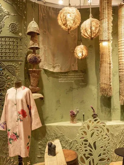 A wide shot of the curated display for 'Edge of the Forest'. The scene includes handcrafted objects, textiles, and furniture that speak to the theme of healing through nature and tradition.