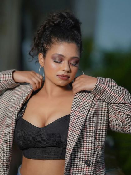 A chic and modern look featuring a brown smoky eye and a matte brown lip. This makeup complements the model's business-casual styling, making it suitable for corporate or fashion lookbooks.