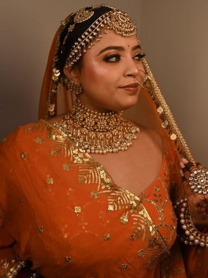 Another angle of the orange lehenga, showing the beautiful gold sequin work on the dupatta.