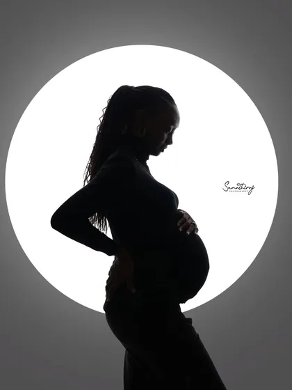 A classic solo silhouette against a circular light source. The clean lines and dramatic contrast create a modern and artistic portrait of the mother-to-be.