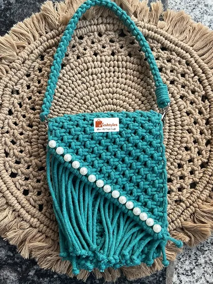 I also make stylish accessories like this beautiful turquoise sling bag. It's handcrafted with a classic macrame knot pattern and finished with pretty pearl details. It’s the perfect size for your phone and essentials when you're on the go.