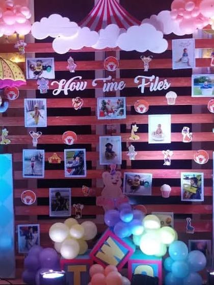 A photo wall from a carnival party with clown cutouts and a 'How Time Flies' theme.