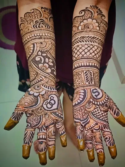 A beautiful example of a personalized engagement mehandi, with the initial "S" and a heart-and-initials lock on the palms.