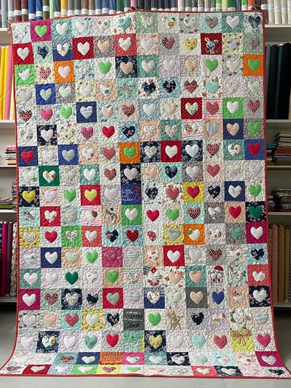 This memory quilt was made entirely from a daughter's baby clothes, with each heart appliqué cut from a different outfit.