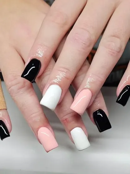 A modern and chic color-blocked manicure using solid black, white, and soft pink on square nails.
