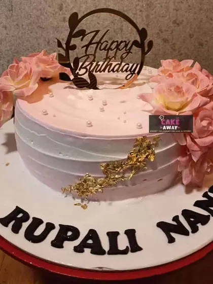 A lovely floral birthday cake for "Rupali Nani." The pink and white buttercream is accented with gold leaf and topped with fresh roses.