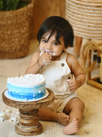 A sweet portrait of the baby mid-celebration during his cake smash photoshoot.