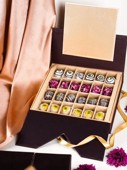 A luxurious Diwali gift box with an assortment of modern Indian sweets (mithai). The elegant packaging and sophisticated styling are perfect for a premium sweets brand.