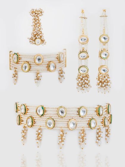 The complete kundan and pearl set, including two choker options, earrings, and a matching maang teeka.