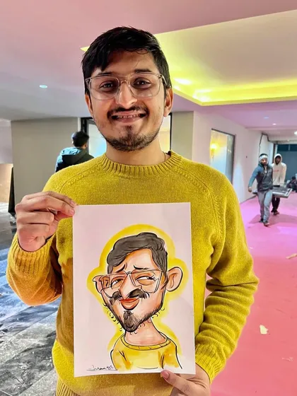 A happy guest in a bright yellow sweater holding his equally colorful caricature. These are the perfect, joyful memories to frame.