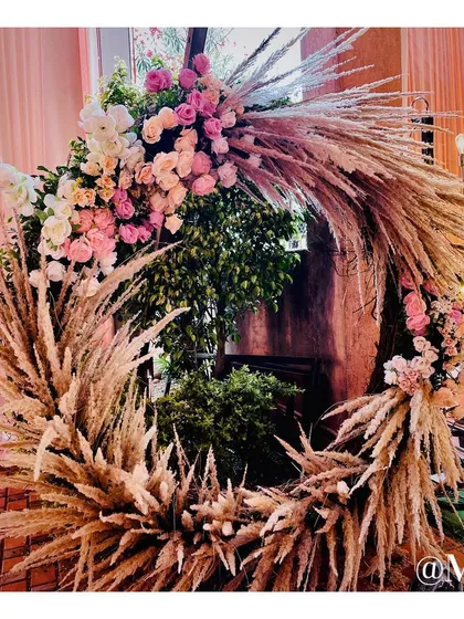 A beautiful circular photo booth backdrop made from pampas grass and pastel roses. This rustic and chic design is perfect for creating soft, romantic pictures.
