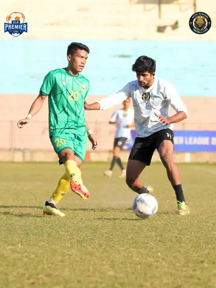 A player shields the ball from a defender, showing strength and control.