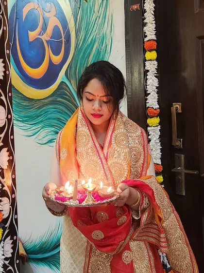 Holding a thali of diyas, this look captures the essence of Diwali. The outfit's rich colors and traditional design are perfect for festive rituals.
