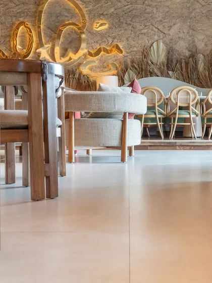 A closer look at the smooth, polished concrete-style flooring at One 8 Commune, which contrasts with the rustic, textured wall surfaces in the background.