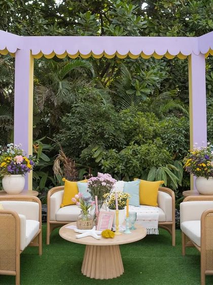 A French-inspired lounge area with cane furniture and a pastel color palette, part of our 'Côte d'Amour' mehendi.