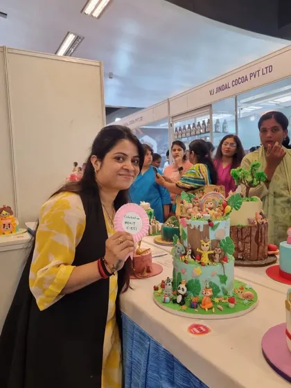 A fun moment at the competition, holding a "Best in Show" sign next to my cake.