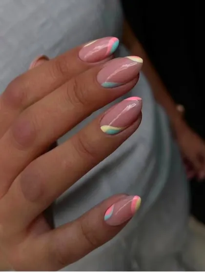 A client's photo of her abstract pastel French manicure. The wavy color blocks give a modern, artistic feel to the nails.
