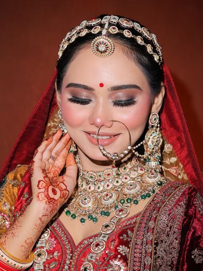 The smile of a bride. This shot captures the complete look, including the intricate henna and jewelry, all part of the overall styling our students learn to consider.