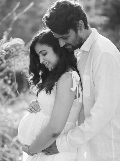 A gentle embrace in the soft light of the outdoors. This black and white photo has a timeless, romantic feel, capturing a quiet moment of connection.