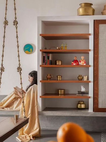 The built-in shelving unit with a sliding fabric panel provides flexible storage and display, blending seamlessly with the wall.