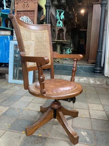 A vintage-style swivel office chair I customized for a client. It's made from solid teak with a caned backrest and a comfortable leatherette seat, combining ergonomic function with classic design.
