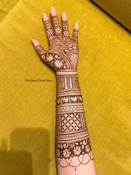 A full-arm design perfect for any festival. The patterns are a mix of geometric shapes, floral bands, and tiny elephant figures.