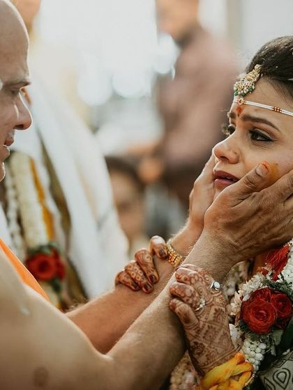 An emotional moment between a father and daughter during the wedding ceremony, his hands gently holding her face.