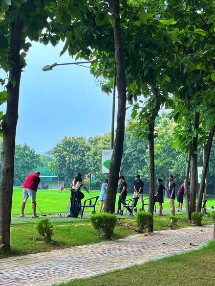 The view from our brick pathway, looking onto a busy driving range lined with trees.