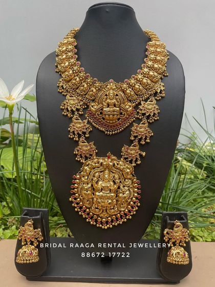 A magnificent bridal set with two large, detailed pendants. The choker and the long haram both feature Goddess Lakshmi, symbolizing wealth and prosperity.