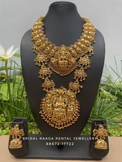 A magnificent bridal set with two large, detailed pendants. The choker and the long haram both feature Goddess Lakshmi, symbolizing wealth and prosperity.
