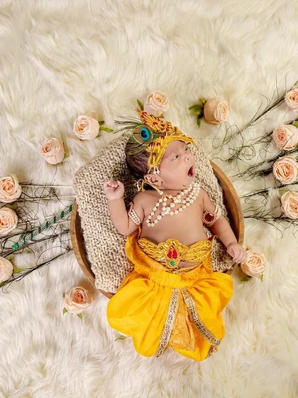 A sleepy yawn from a tiny Krishna. This is an example of our themed newborn photoshoots, where we use beautiful props like peacock feathers and soft wraps to create a magical and safe setting for your baby.