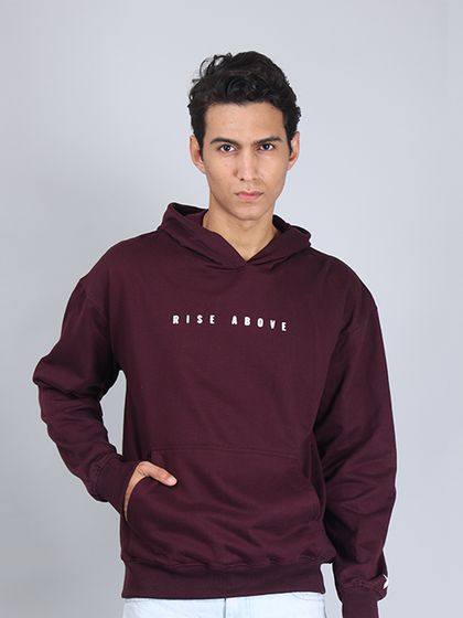 A front-facing shot of a model wearing a maroon "Rise Above" hoodie. This clean, centered look is perfect for catalog and e-commerce websites.