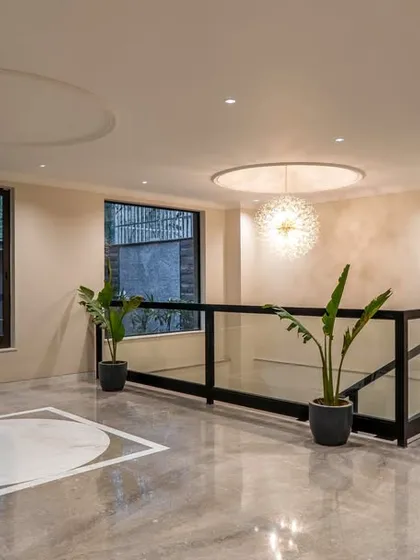 The common areas of this project are an exercise in minimalistic luxury. This lobby space features elegant marble flooring with a custom inlay, creating a sophisticated first impression.