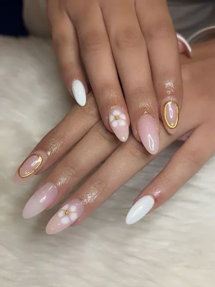 It's all in the details. This set combines milky white nails, 3D flowers, and gold chrome outlined accent nails.