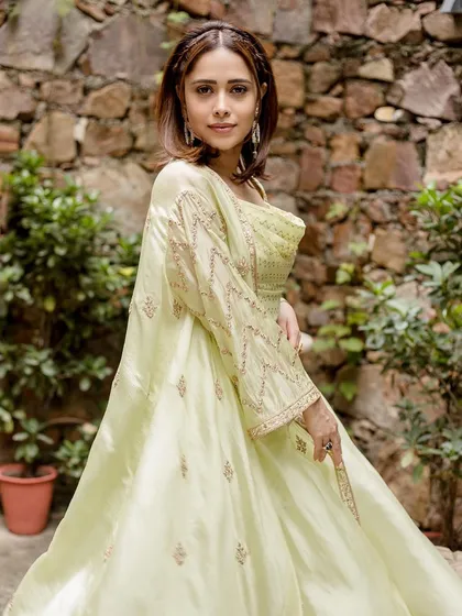 This lime green draped outfit by Punit Balanani on Nushrratt Bharuccha is perfect for a destination wedding. The cowl top and draped skirt create a chic, resort-style ethnic look.