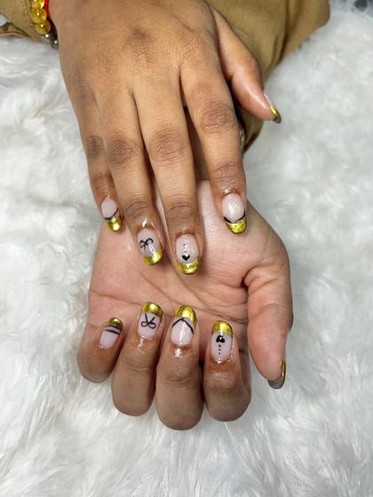 This angle shows the different designs on each nail, all tied together with the beautiful gold chrome French tip. It's a great way to have a cohesive yet varied look.